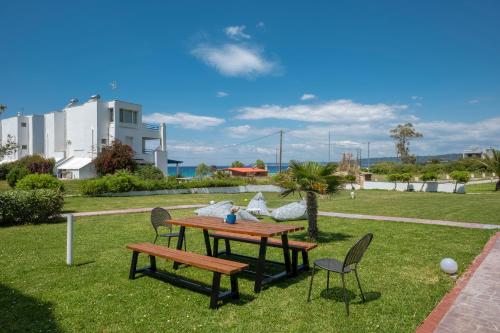 a picnic table and two chairs in a yard at Sunset Villas in Possidi