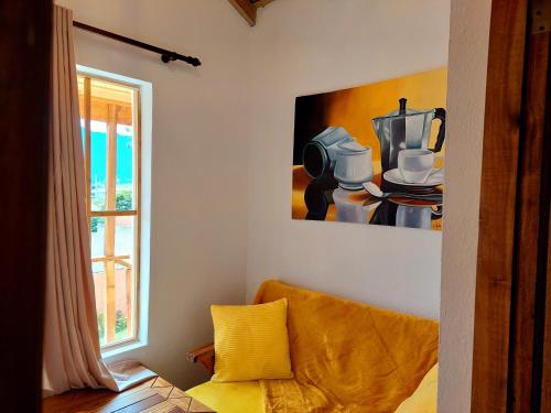 a living room with a yellow couch and a painting at Villas Montelindo in Constanza