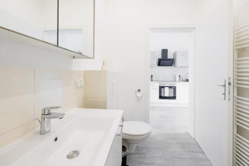 ein weißes Badezimmer mit Toilette und Waschbecken in der Unterkunft Charming Apartment near Center in Wien