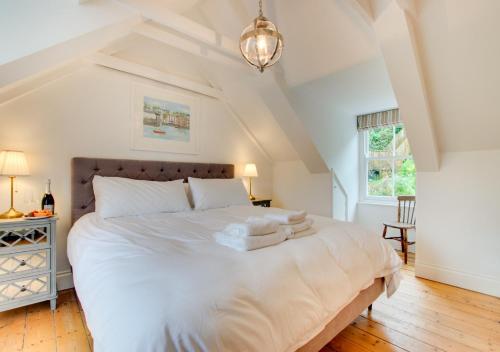 a bedroom with a large white bed with towels on it at Waters Reach in Fowey