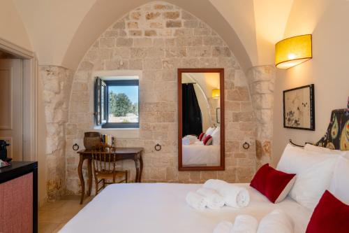 a bedroom with a large bed and a mirror at Masseria Santo Scalone in Ostuni