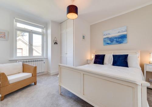 a bedroom with a large white bed and a chair at Uplands in Praa Sands