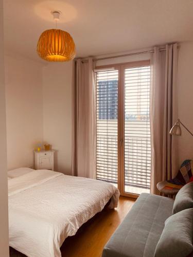 a bedroom with a bed and a large window at Appartement T3 Confluence in Lyon