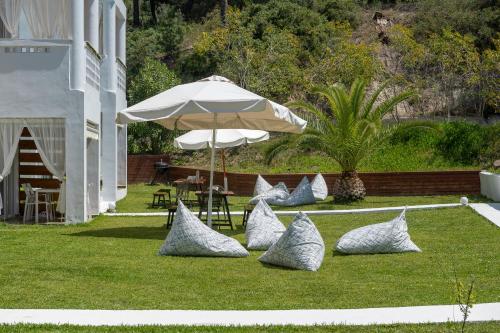 a group of pillows sitting on the grass with an umbrella at Sunset Villas in Possidi