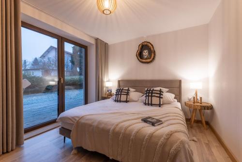 a bedroom with a bed and a large window at Anielski Zakątek Solina - balia z jacuzzi i sauna w cenie pobytu in Solina
