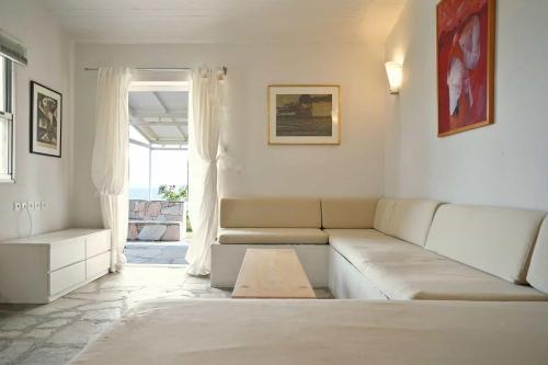 a living room with a couch and a window at Alterra Vita Captain's Cabin in Neos Marmaras