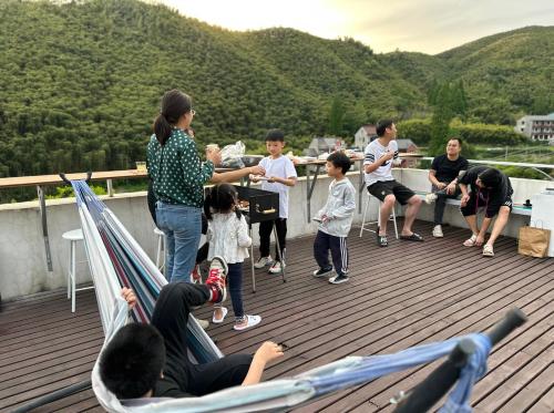 a group of people standing on a deck at Moganshan Naicang Boutique Hotel in Deqing