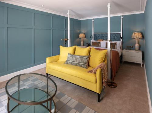 a living room with a yellow couch and a bed at The City of London Club in London