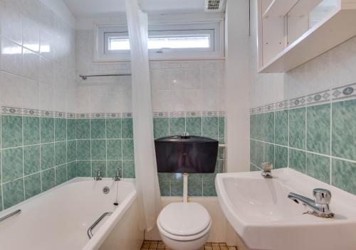 uma casa de banho com um WC, uma banheira e um lavatório. em Pine Tree Cabin em Saint Merryn