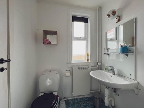 biała łazienka z toaletą i umywalką w obiekcie Akraberg Lighthouse Lodge w mieście Sumba