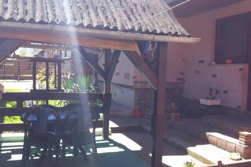 une terrasse avec une table et des chaises dans une maison dans l'établissement Kod Komse, à Srbobran