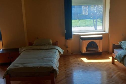 Cette chambre comprend 2 lits jumeaux et une fenêtre. dans l'établissement Kod Komse, à Srbobran