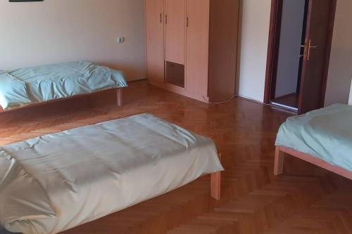 - une chambre avec 2 lits et du parquet dans l'établissement Kod Komse, à Srbobran