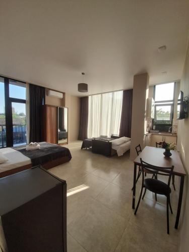 ein Hotelzimmer mit einem Bett, einem Schreibtisch und einem Tisch in der Unterkunft Noes House in Kobuleti