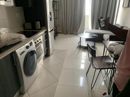 een keuken met een fornuis, een koelkast en een tafel bij Prinarks luxury Apartment in Accra