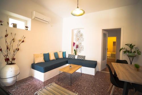 ein Wohnzimmer mit einem blauen Sofa und einem Tisch in der Unterkunft Morning Star Traditional Houses in Pirgos