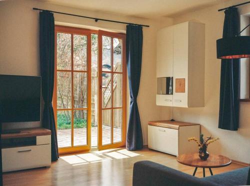 a living room with a couch and a tv and a window at Apartment im Obstgarten in Rottau