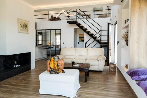 a living room with a white couch and a fireplace at OLIVOMARE in Kyparissia