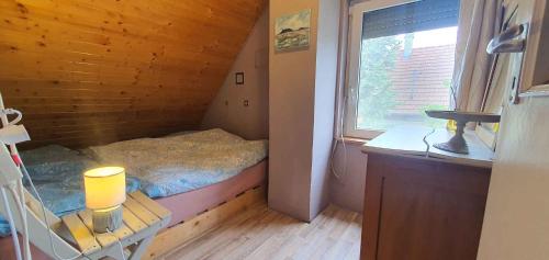 a small bedroom with a bed and a window at Apartment Balatonfenyves - Balaton 26709 in Balatonfenyves