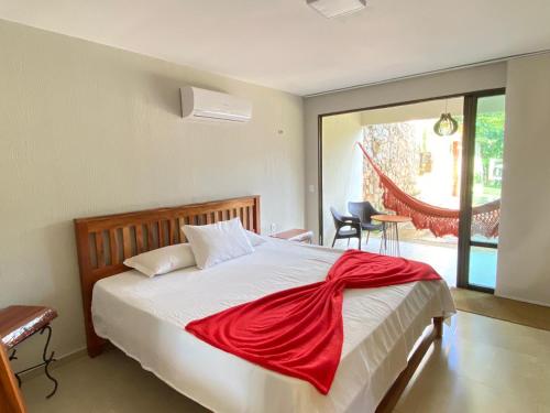 een slaapkamer met een bed met een rode deken erop bij Chalé Novo - 4 quartos - 12 camas - Hidromassagem e Ar condicionado nos quartos - Cond Montserrat in Guaramiranga