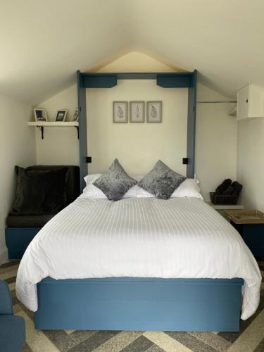 1 dormitorio con 1 cama grande y cabecero azul en The Hen House, 