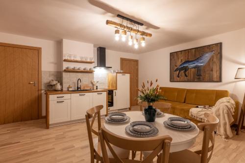 a kitchen and a living room with a table and chairs at Anielski Zakątek Solina - balia z jacuzzi i sauna w cenie pobytu in Solina