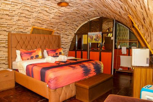 a bedroom with a bed and a brick wall at Little Amanya Camp Amboseli in Amboseli