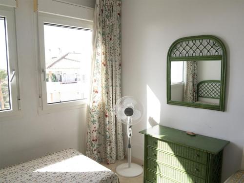 een slaapkamer met een groene dressoir en een spiegel bij Casa del Mar in Zahara de los Atunes