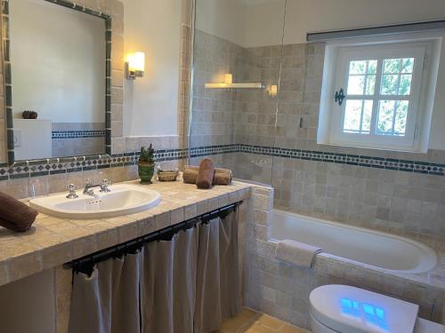 een badkamer met een wastafel, een bad en een toilet bij La Paradoune 2 in Paradou