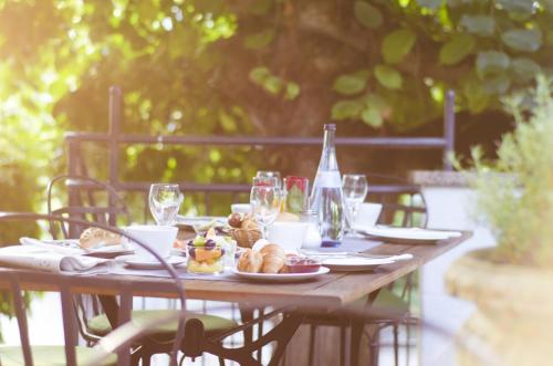 a wooden table with plates of food and a bottle of wine at Bodenseehotel Renn in Hagnau