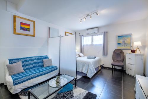 een woonkamer met een bank en een bed bij Bas de villa, piscine, 3 étoiles in Saint-Paul-de-Vence