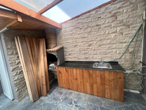 eine Küche mit Spüle und Ziegelwand in der Unterkunft Magnifique maison bord de mer Canet plage in Canet-en-Roussillon
