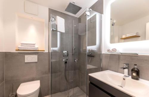 een badkamer met een douche, een toilet en een wastafel bij Haus Andersen Apartment DREI in Norderney