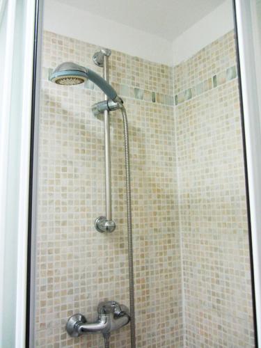 une douche avec pommeau de douche dans une salle de bain dans l'établissement Studios Belges, à Cannes