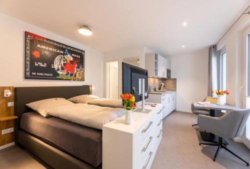 een slaapkamer met een groot bed en een bureau met een televisie bij Haus Andersen Apartment DREI in Norderney