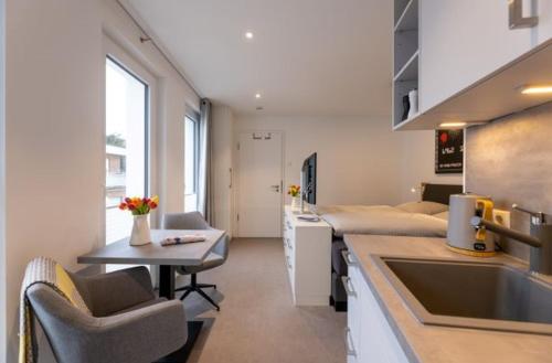 una camera con due letti e una cucina con lavandino di Haus Andersen Apartment DREI a Norderney