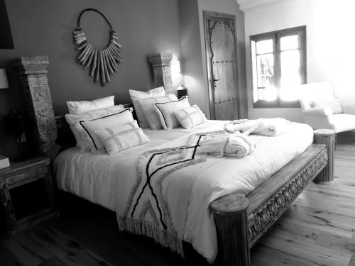 a bedroom with a large bed with white sheets and pillows at El Violin Experiencia Adults only in Melegis