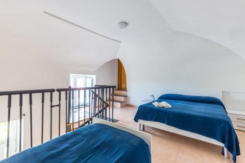 a bedroom with two beds and a balcony at La TERRAZZA sul GIARDINO in Procida