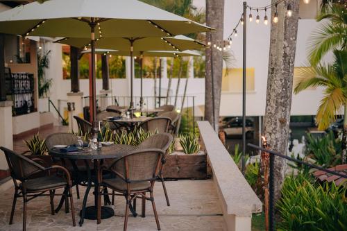 a patio with tables and chairs under an umbrella at Parador Nature Resort and Spa in Manuel Antonio