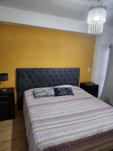 1 dormitorio con 1 cama con manta azul y blanca en Departamentos Dany en Buenos Aires