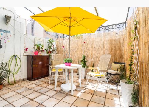 a patio with a table and a yellow umbrella at Habitación Apartamento Suite Papillon in Valencia