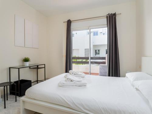 エステポナにある2051-New 3 bedrooms on golfの白いベッドルーム(ベッド1台、窓付)