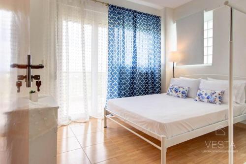 un letto bianco in una stanza con finestra di Summer Treasure 2-bdrm Maisonette in Trani Ammouda a Ormos Panagias