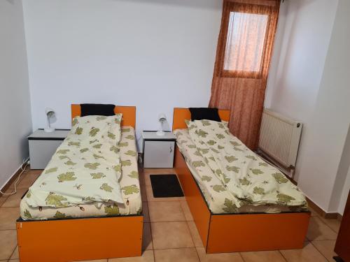 two beds in a room with two tables at OGADUGU in Bucharest