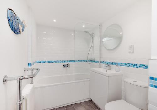 a white bathroom with a shower and a toilet at Cosy Nook in Appledore