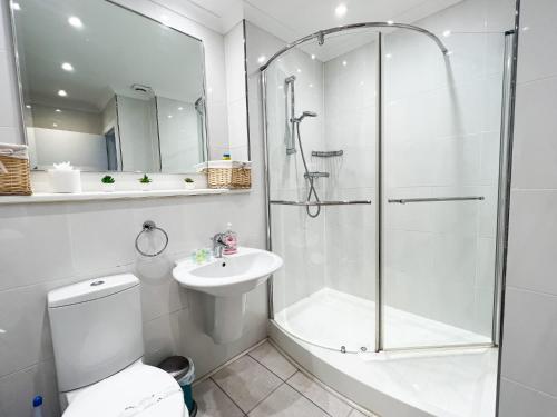 a bathroom with a shower and a toilet and a sink at A Spacious Flat with Character - Private Car Space in Paisley