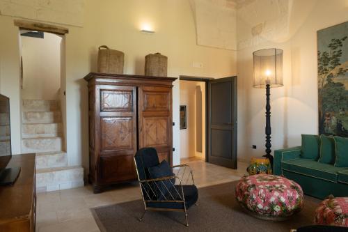 a living room with a green couch and a chair at Masseria Santo Scalone in Ostuni