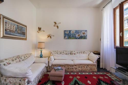 sala de estar con 2 sofás y TV en Uno Scorcio sul Mare by Wonderful Italy, en Santa Margherita Ligure