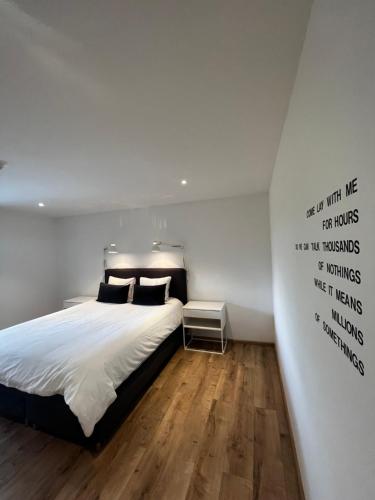 een slaapkamer met een bed met woorden op de muur bij Le Vieux Moulin in Marche-en-Famenne