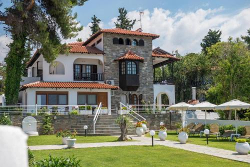 een huis met een tuin ervoor bij Georgalas Sun Beach Resort in Nea Kalikratia